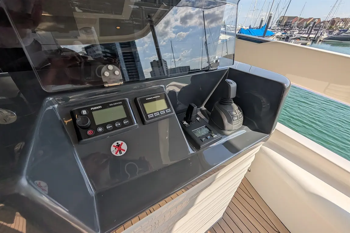 Yacht control panel featuring controls, a Fusion audio system, and a Volvo Penta monitor with a prohibition sign visible.